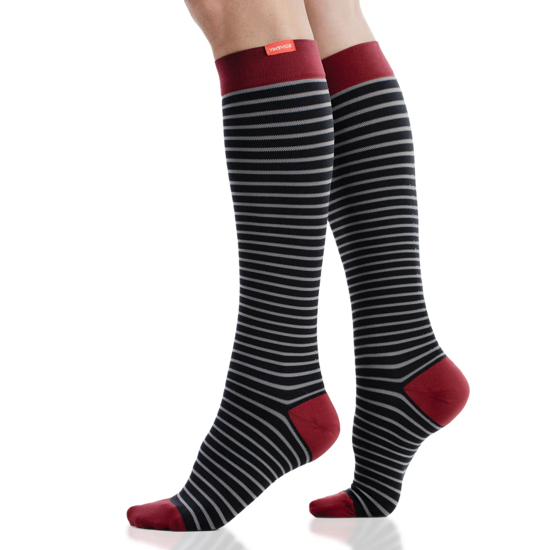 Black and white striped Vim & Vigr knee-high compression socks with red heels and toes
