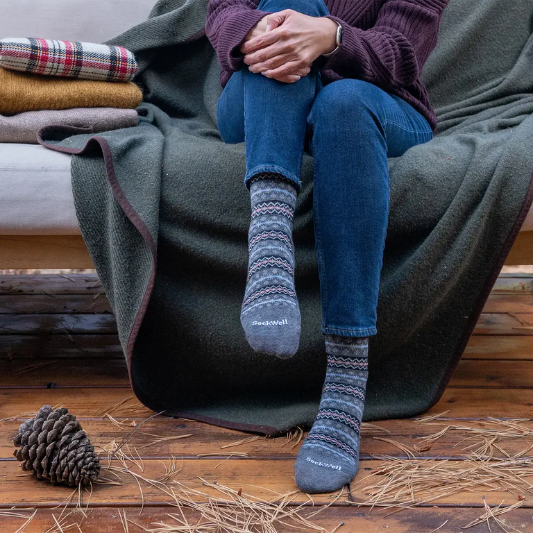 Cozy patterned Sockwell merino wool socks worn at home with a blanket